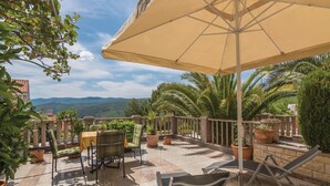 A terrace with a table and chairs, a large umbrella, and potted plants. - 1 bedroom nice apartment in Rabac (Rabac)
