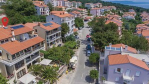 A residential area with multi-story buildings, a main road, and parked cars. - 1 bedroom nice apartment in Rabac (Rabac)