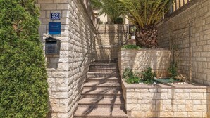 A narrow stone staircase leading to a building entrance, with a mailbox and a sign indicating the address. - Lovely apartment in Rabac with WiFi (Rabac)