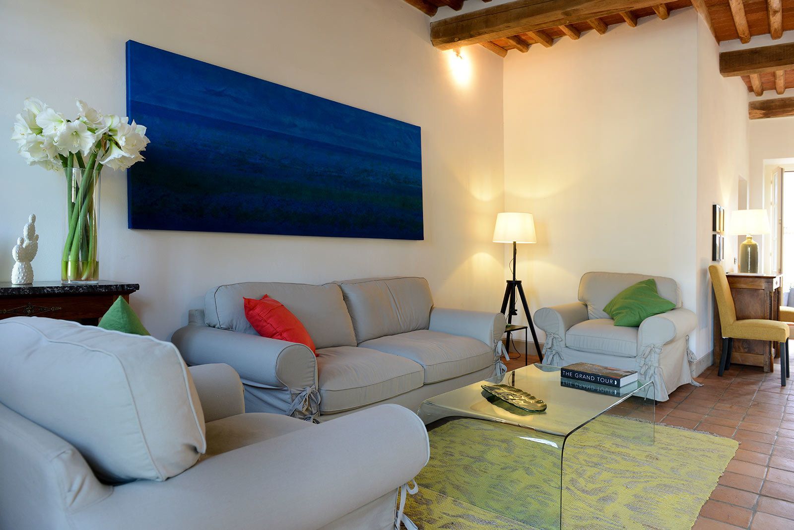 A living room with two sofas, a coffee table, a lamp, and a painting on the wall.