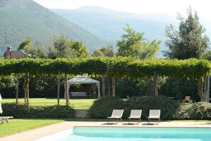 Una piscina al aire libre, sombrillas, tumbonas