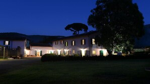 A two-story building with multiple windows and a large tree in front. - Guesthouse ai Santinelli (Capannori)