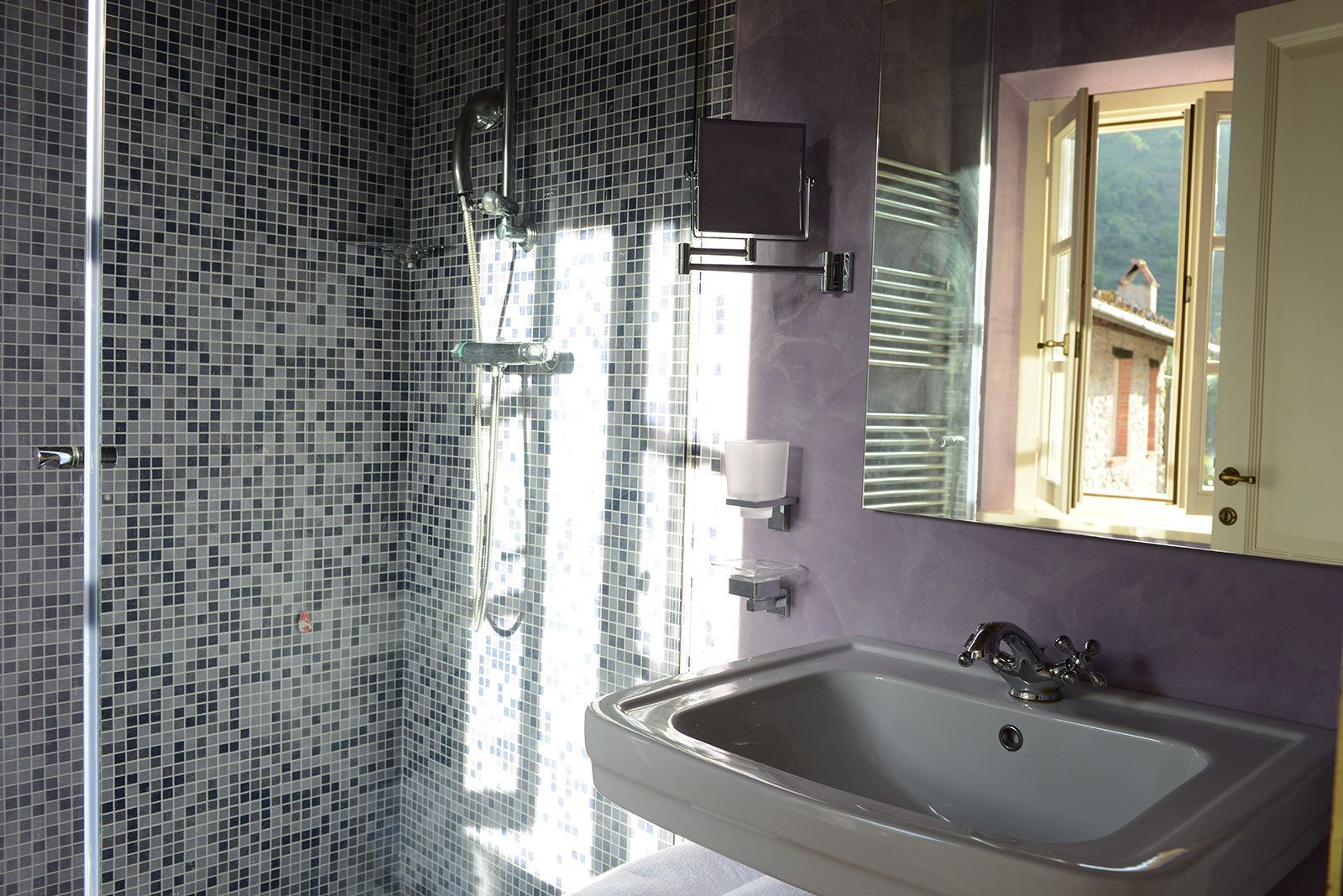 Une salle de bain avec une douche, un lavabo et un miroir.