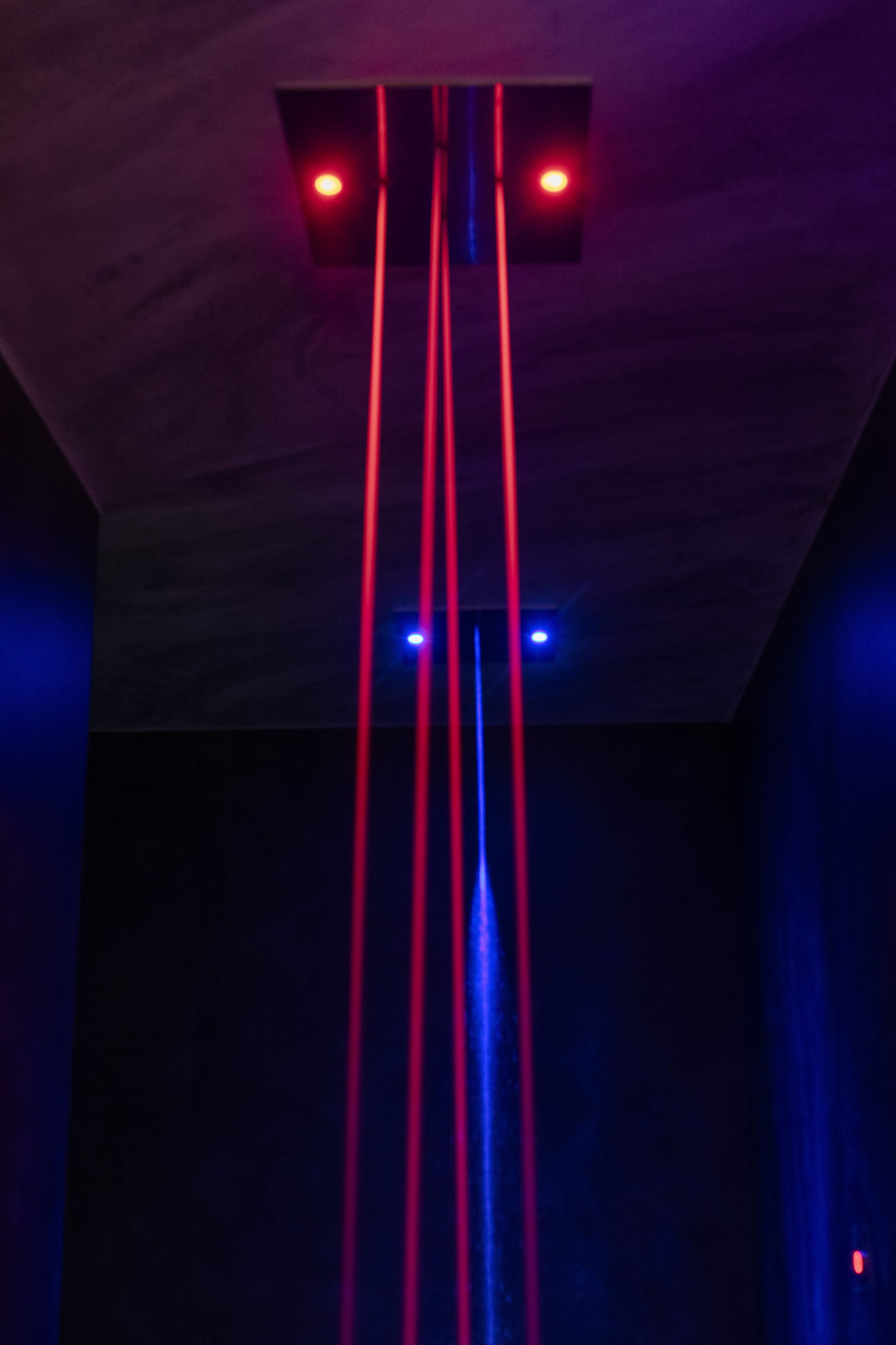 A ceiling with red and blue vertical light beams.