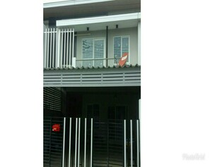 Two-story building with a balcony and gated entrance.