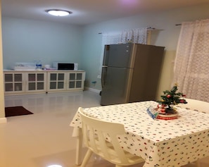 Cozy kitchen with a dining area, featuring a refrigerator, microwave, and table for meals.