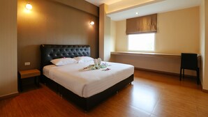 A bedroom with a large bed, a bench, a chair, and a window with a view. - Triple Trees (Lam Luk Ka)