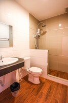 Un baño con lavamanos, inodoro y ducha blancos.