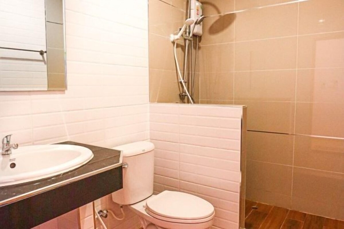 A bathroom with a white sink, toilet, and shower.