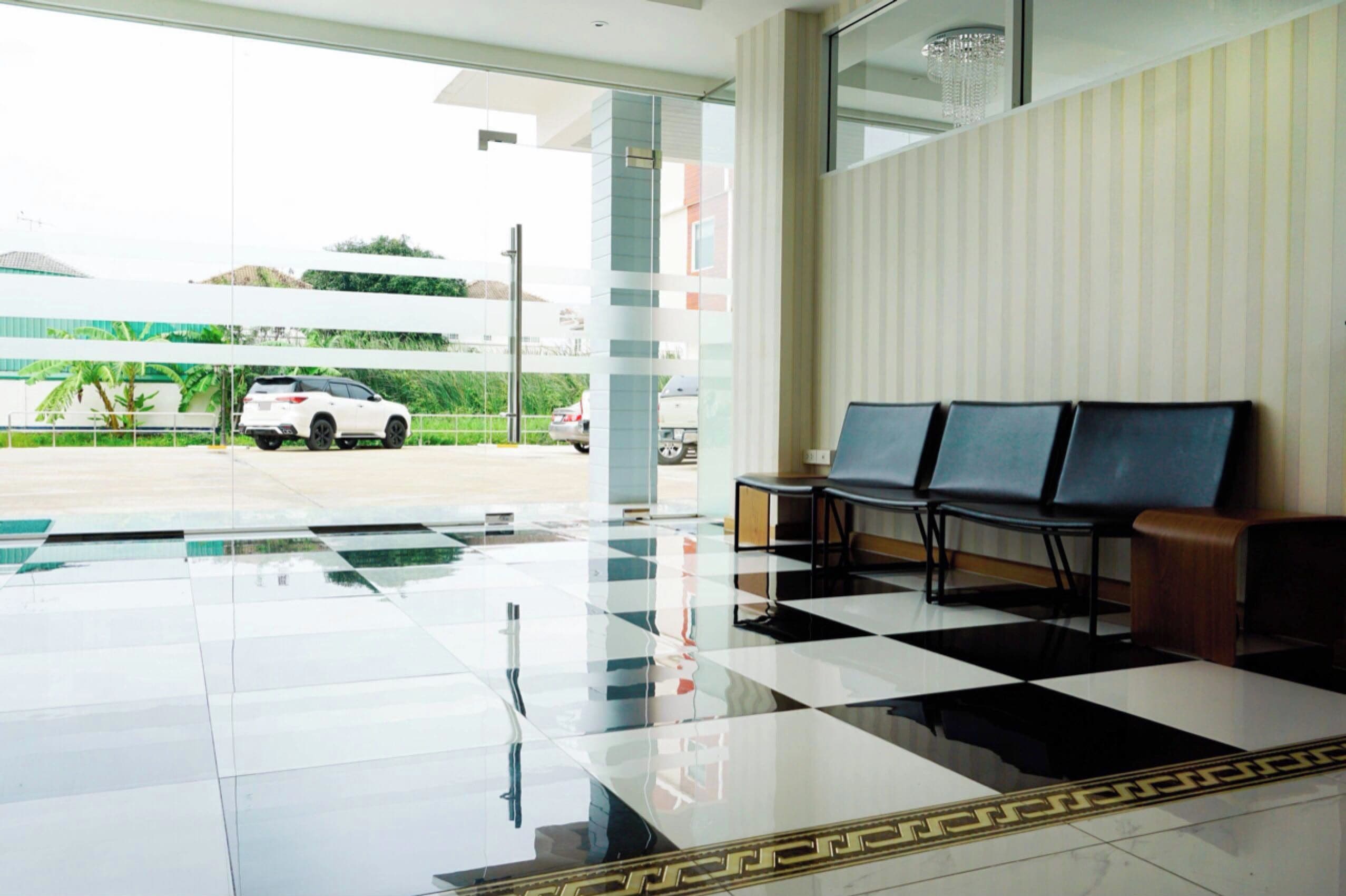 A lobby with a checkered floor, a reception desk, and a seating area with chairs.