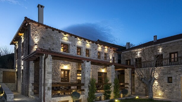 A stone building with multiple windows and a covered patio area. - Elafos Spa Hotel (Gortynia)