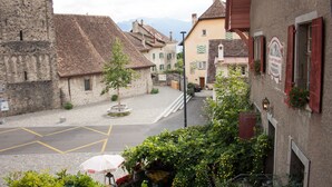 Straßenansicht mit Gebäuden, einem Glockenturm und blauem Himmel.