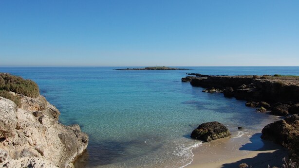 A coastal landscape with clear blue waters, rocky shores, and a distant island. - Idyllic country house, panoramic pool with sea views, quiet, WiFi, heating, 7 people (Siracusa)