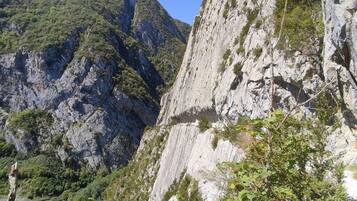 A mountainous landscape with rocky cliffs and dense greenery.
