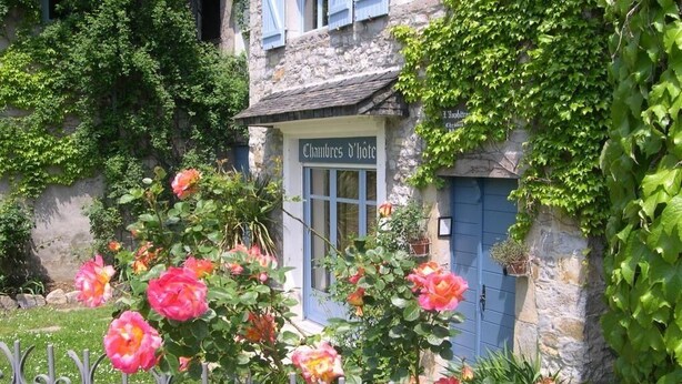 A stone building with a sign reading "Chambres d'Hotel".