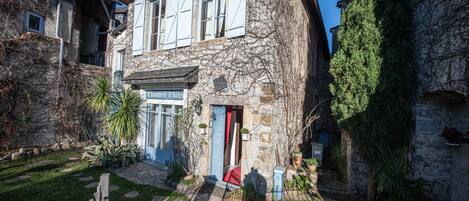 A stone building with a blue door and a sign that reads "Chambres d'hôtes."