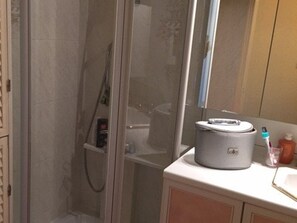A bathroom with a shower, a sink, and a mirror. - Apartment T3, 6 pers, BBQ, terrace, parking, beach nearby (Port Barcarès)