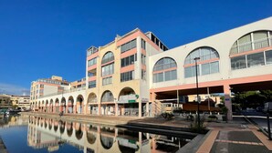 Un hôtel situé au bord de l’eau, doté d’une piscine à effet miroir, de nombreux balcons et d’une promenade couverte.