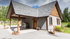 Una casa moderna con tetto a falda, veranda e zona barbecue.