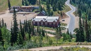 Eine Lodge mit mehreren Gebäuden, einer kurvenreichen Straße und einem bewaldeten Gebiet.