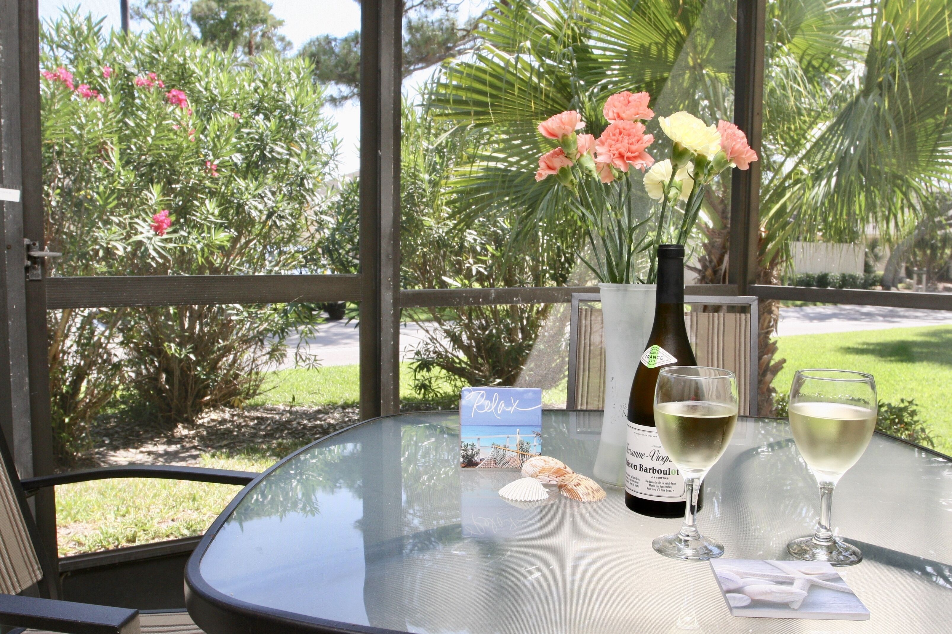 A table with a bottle of wine, two glasses, a card, and a small decorative item.