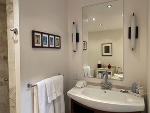 Ein Badezimmer mit einem großen Spiegel, einem Waschbecken und einem Handtuchhalter.