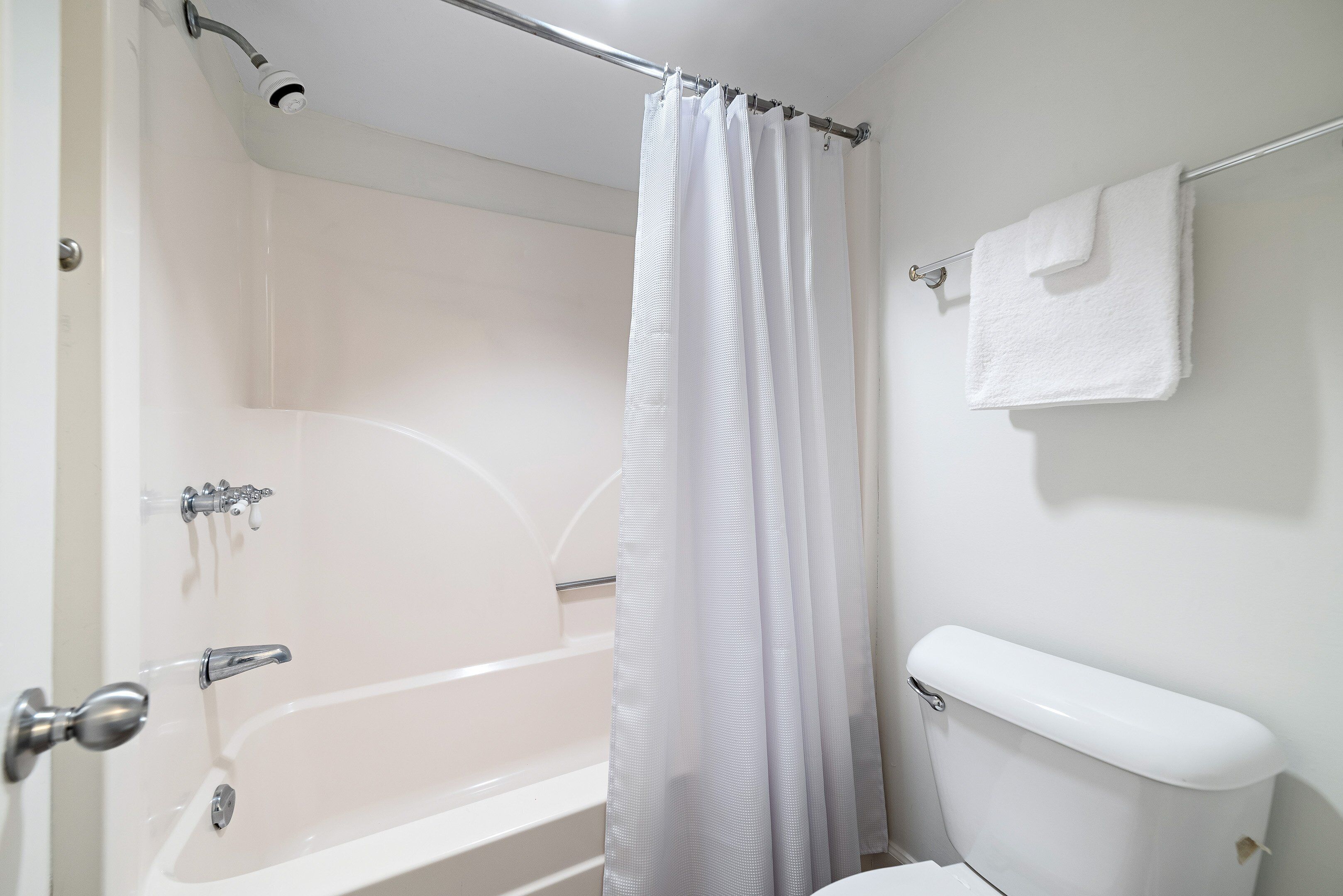 Une salle de bain avec une baignoire, des toilettes et un rideau de douche.