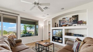 Una sala de estar con sofá, mesa de centro y mueble para televisión.