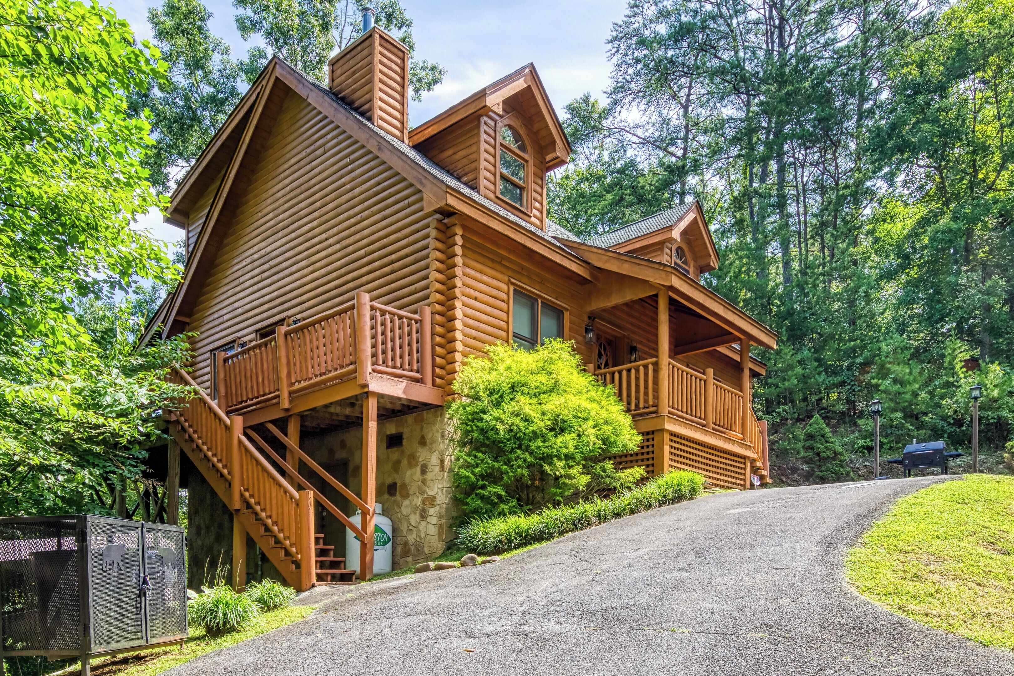 A log cabin with a stone foundation, wooden balconies, and a stone staircase.