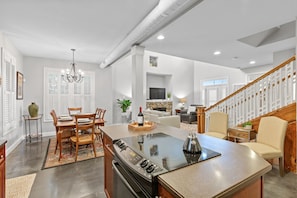 A modern kitchen with a central island, dining area, and a staircase leading to another level. - Elegant Downtown Chattanooga Retreat Near Riverfront & UTC Sleeps 6 Fireplace (Chattanooga)