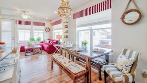 Amplia sala de estar con una mesa de comedor de madera, un sofá rojo y un banco.