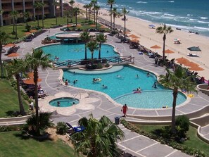 Et resort med flere swimmingpools, palmer og en strand.