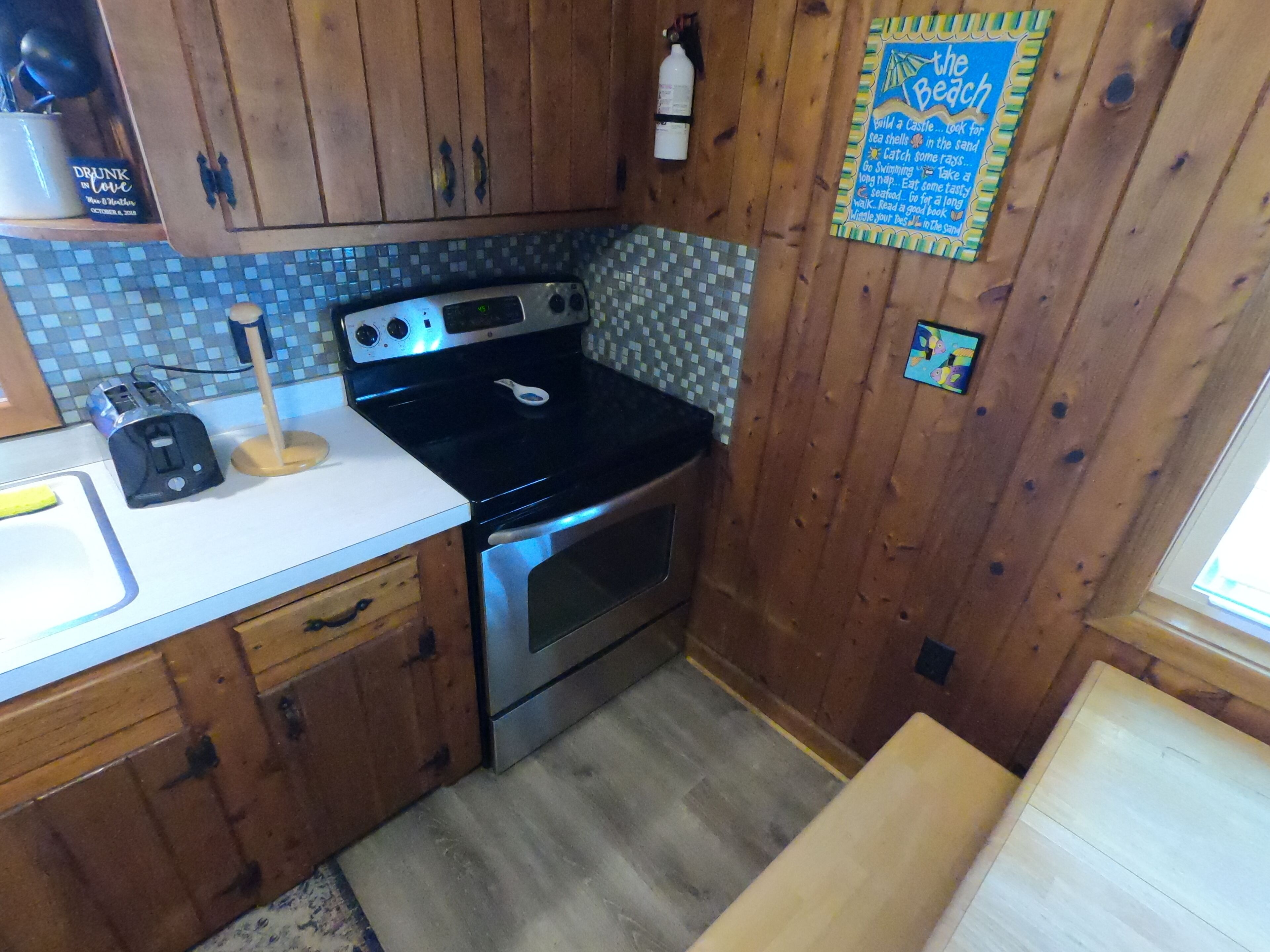 A kitchen with wooden cabinets, a microwave, an oven, and a tiled backsplash.