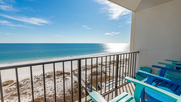 A balcony with a view of the beach and ocean.