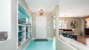 A hallway with a white door, a blue wall, and a white sofa. - Beautiful Home in Old Town Cottonwood WALK to Wine Tasting Rooms & Restaurants! (Cottonwood)