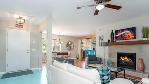 A modern living room with a white sofa, a fireplace, and a television. - Beautiful Home in Old Town Cottonwood WALK to Wine Tasting Rooms & Restaurants! (Cottonwood)
