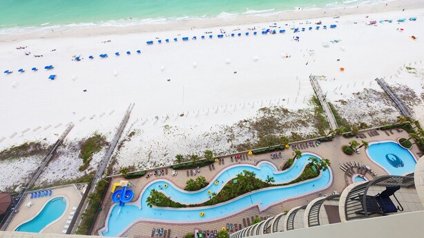 Ein Resort mit Strand, Poolbereich und Rettungsturm.