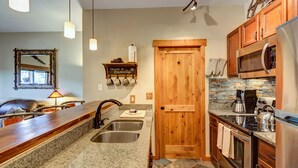 A kitchen with granite countertops, stainless steel appliances, and wooden cabinets.