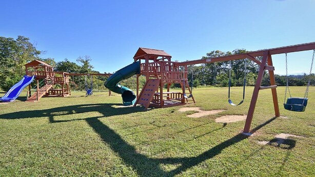 A playground with a slide, swings, and climbing structures. -  Luxury Designer 3/2 Condo! Come Relax & Unwind, and Enjoy!!! (Pigeon Forge)