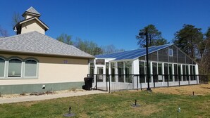 A greenhouse with a glass roof and a building with a grey roof and green windows. -  Luxury Designer 3/2 Condo! Come Relax & Unwind, and Enjoy!!! (Pigeon Forge)