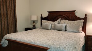 A bedroom with a wooden bed, a ceiling fan, a nightstand with a lamp, and a wooden floor. -  Luxury Designer 3/2 Condo! Come Relax & Unwind, and Enjoy!!! (Pigeon Forge)