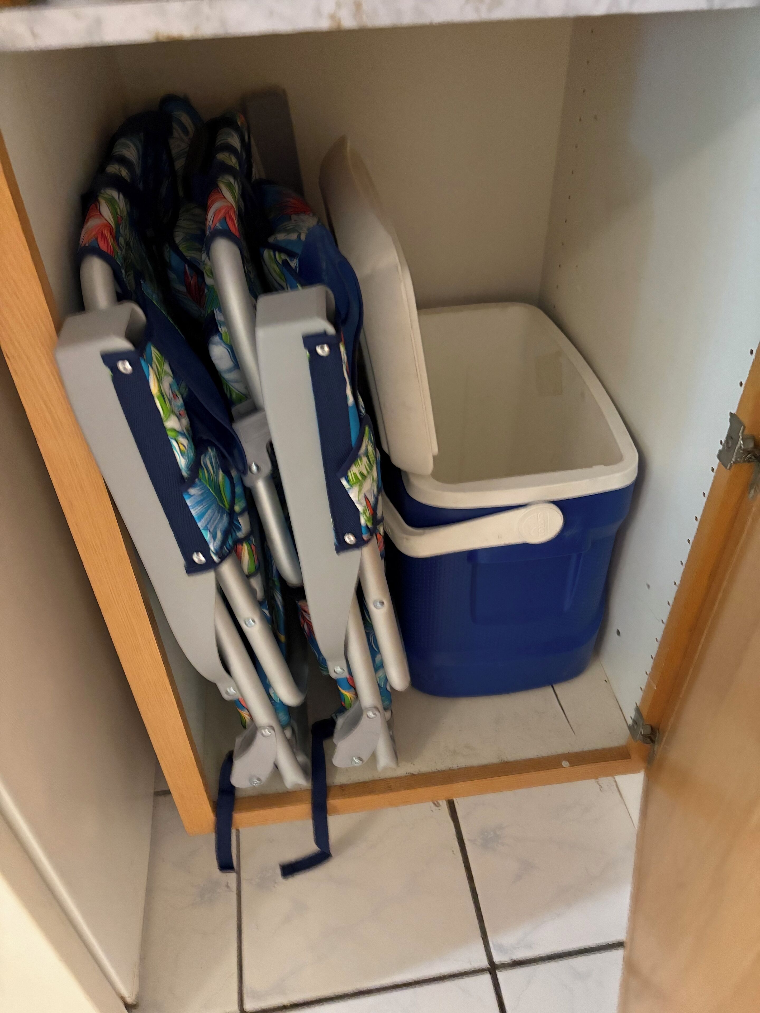 A storage area with a blue plastic bin and a pair of crutches leaning against a wall.