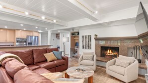 A modern living room with a leather sofa, armchairs, a coffee table, and a fireplace.
