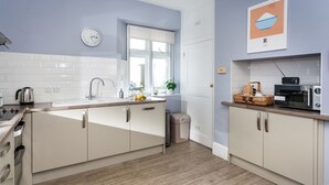 A modern kitchen with white cabinets, a stainless steel sink, and a microwave.