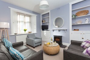 A living room with a fireplace, a television, and a bookshelf.