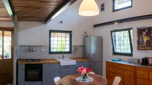 A kitchen with a wooden ceiling, a dining table with chairs, a vase of flowers, and a refrigerator. - Vacation home La Vigna with Pool (San Toma')