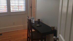 A dining area with a black table, two chairs, a TV mounted on the wall, and a door with a keychain. - Alecia B&B (Atlanta)