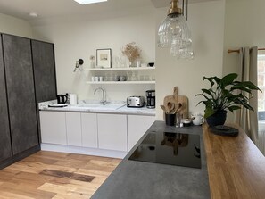 Enjoy cooking in this kitchen with a central island and ample counter space, featuring a coffee maker, toaster, and sink.