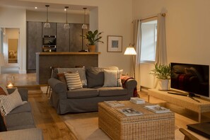 Relax in this stylish living room with a sofa, coffee table, and flat-screen TV.
