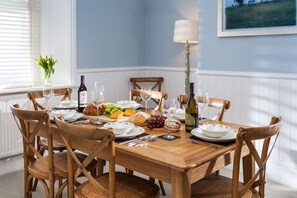 A dining table set with plates, glasses, and a variety of food items.